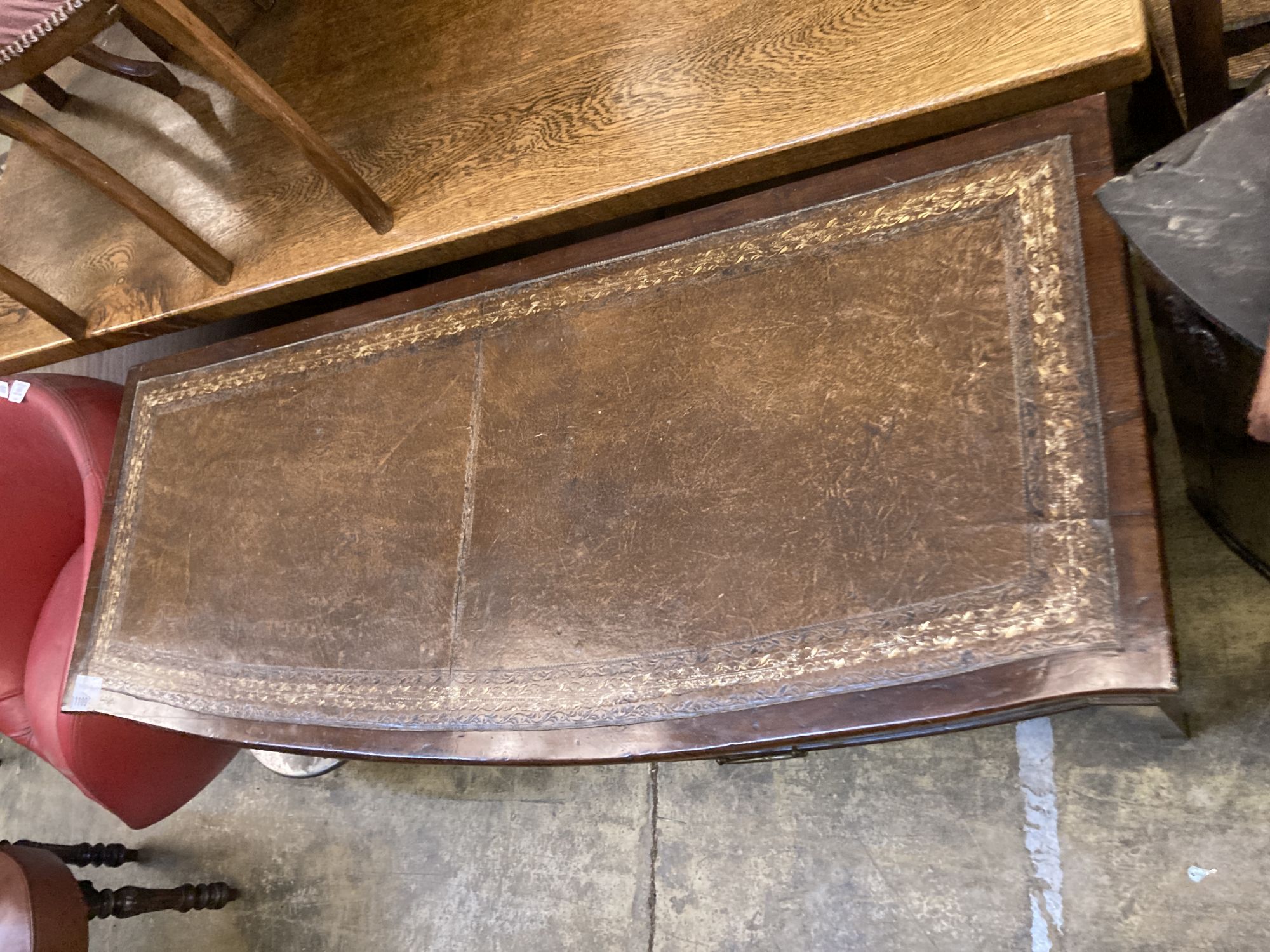 A George III style mahogany bow front writing table, width 123cm, depth 50cm, 74cm